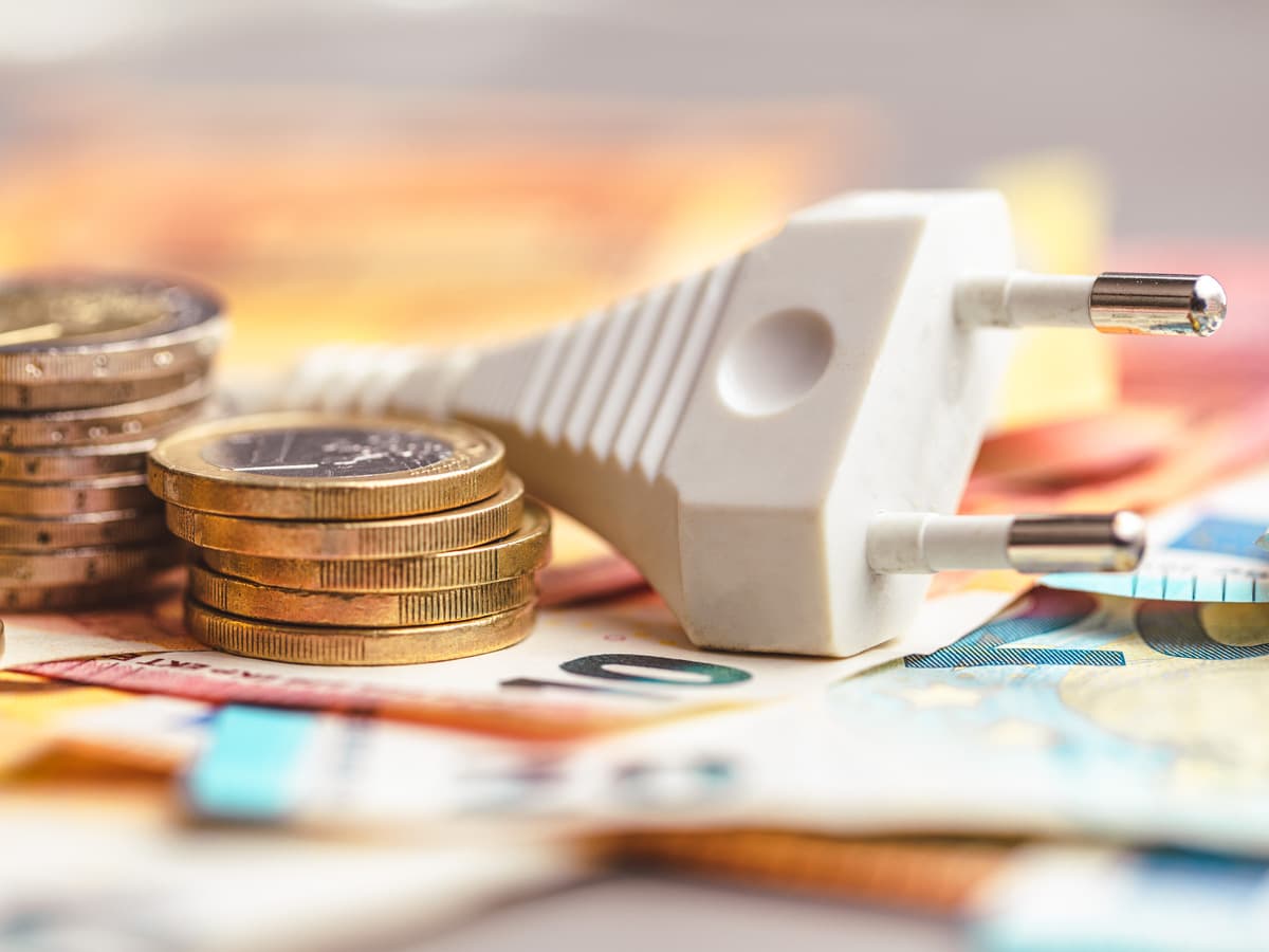 Eluttag med pengar som symboliserar elbesparing